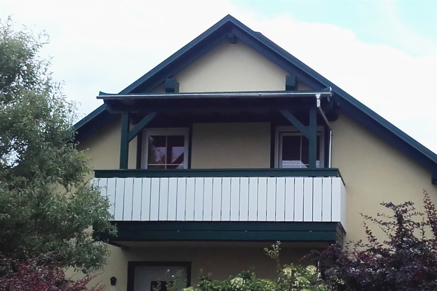 Balkon mit Holzverkleidung an einem Wohnhaus